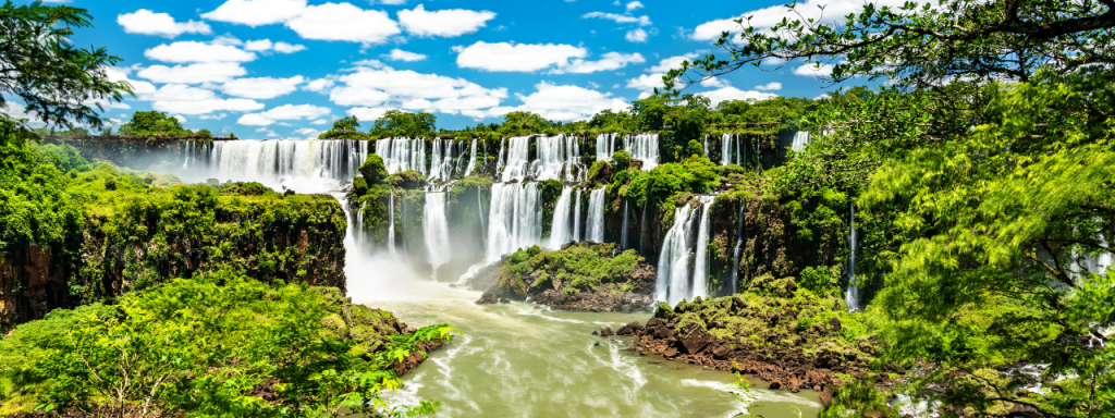Imagem das quedas d’água das Cataratas do Iguaçu, cercadas por vegetação exuberante