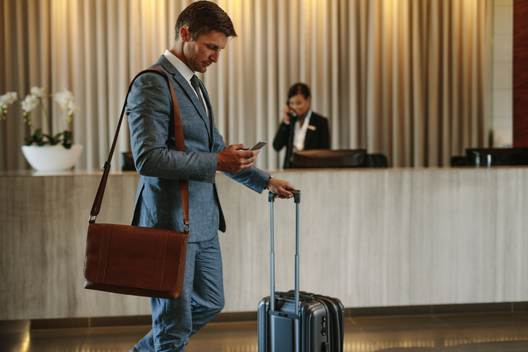 Executivo caminhando com sua mala em um hotel