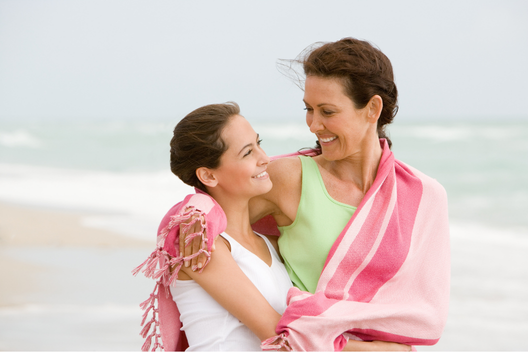 mãe e filha abraçadas na praia